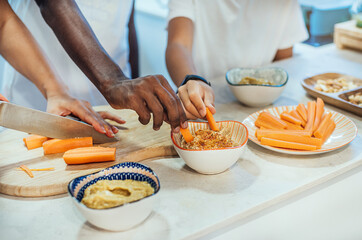 two children of different ethnicities taste a recipe made by their mother. family cooking and diversity concept.