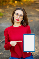 Girl in red sweater with mockup tablet. Girl with glasses and tablet mockup