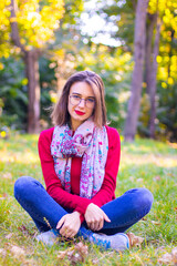 Obraz premium Girl in red sweater in nature. Girl in red in nature. Girl with red lips. Autumn photo
