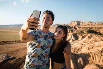 Young caucasian couple taking a selfie at Bardenas Reales, Navarra, Basque Country.