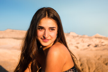 Young caucasian woman posing in Bardenas Reales desert at sunset time. Navarra, Basque Country.