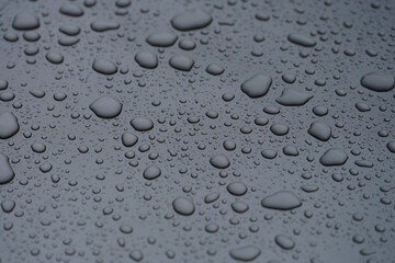 Closeup of raindrops on dark glass background