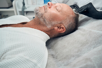 Obraz premium Man receiving injection for hair growth in cosmetology clinic