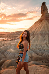 Young caucasian woman with a camera in front of Castildetierra formation at Bardenas Reales desert, Navarra, Basque Country.