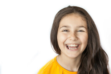 Portrait of happy positive smiling child girl with a long hair in yellow T-shirt isolated on white background