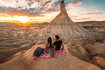 One young man and one young woman watching the sunset at Castildetierra in Bardenas Reales desert, Navarra, Basque Country.