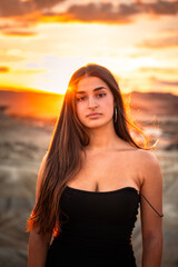 Young caucasian woman with a sexy black dress at sunset time at Bardenas Reales, Navarre, Basque Country.