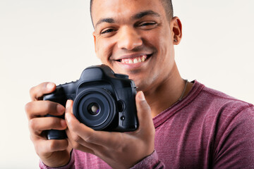 Smiling friendly male photographer holding his camera