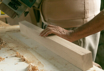 Manos de persona mayor trabajando la madera 