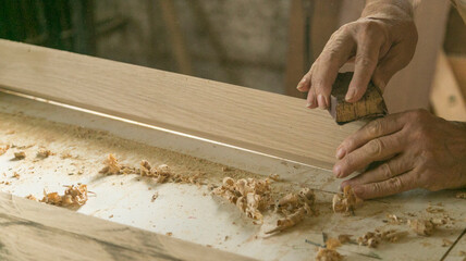 Manos de persona mayor trabajando la madera 