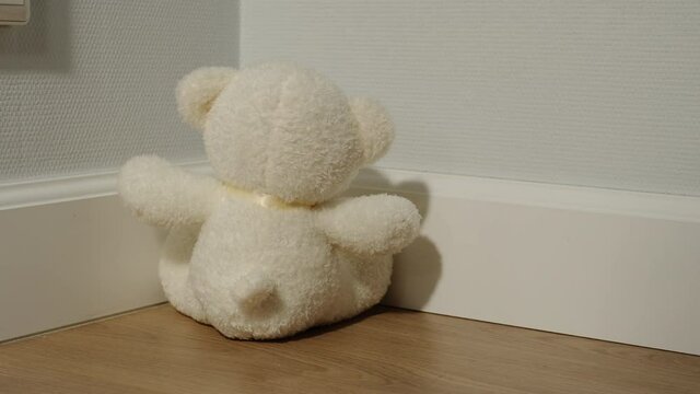 White Plush Bear Toy Sitting Backwards In The Corner Of The Room