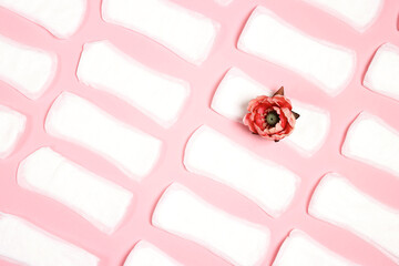 White sanitary pads with peony flower on one of them on pink background.