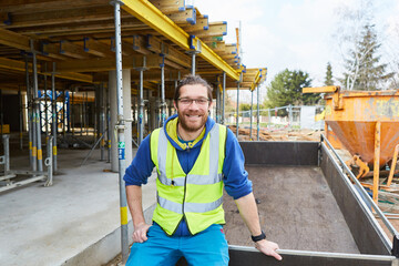 Lächelnder Bauarbeiter Lehrling auf einer Baustelle