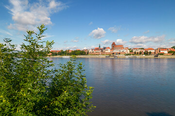 Torun, a Polish city during the day. A sunny and slightly cloudy day in Toruń on the Vistula River. © Olivier Uchmanski