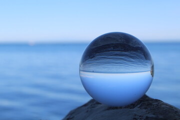 In einer Glaskugel spiegelt sich das Meer