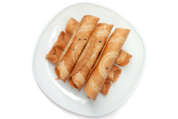 Top view of Crispy golden curl or Thai people call Thong Muan is a snack in white plate isolated on white background.