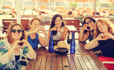 Women best friends sitting in summer cafe on the beach