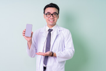 Asian doctor standing on green background