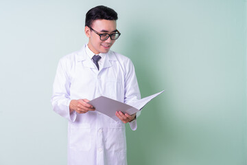 Asian doctor standing on green background