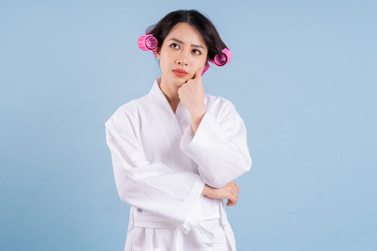 Young Asian Woman Wearing Bathrobe On Blue Background