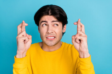 Photo portrait man stressed crossed fingers hope for luck looking copyspace isolated pastel blue...