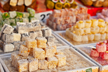 Turkish national sweets are sold at the fair. Multi-colored Asian desserts stacked on the table. Rahat lokum in bulk is sold at the festival.