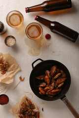 Fresh beer with fried shrimps on a light table, top view