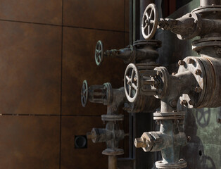 Old rusty valves of industrial oven from steam revolution times with pipes all in steampunk climate