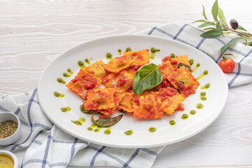 Fototapeta premium ravioli in tomato sauce with spinach leaf