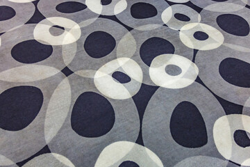 Textured surface of gray wool carpet with circular abstract patterns