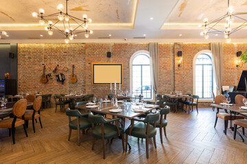 Interior of a modern hotel restaurant with old instruments hanging on the brick wall as a decoration