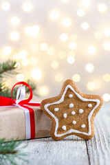 Gingerbread star and box of gift on bokeh lights background