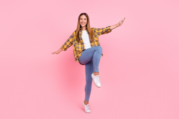 Full length photo of cheerful positive happy young woman raise hands fly plane wings isolated on pink color background