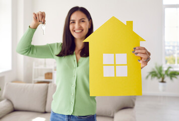 Happy single young woman who has finally saved enough money and bought new home standing in living...