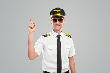 Smiling pilot pointing up with finger