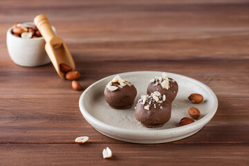 Vegan peanut truffles in chocolate on a plate. Sugar, gluten and lactose free. 