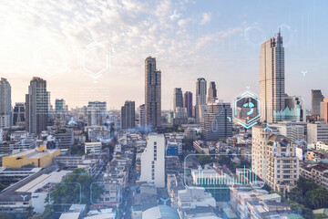 Fototapeta premium Glowing hologram of technological process, aerial panoramic cityscape of Bangkok at sunset. The largest innovative hub of tech services in Southeast Asia. Multi exposure.