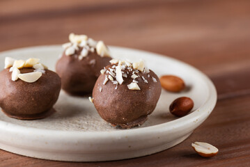 Peanut truffles in chocolate on a plate. Sugar, gluten and lactose free and vegan.