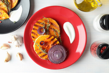 Concept of tasty eating with baked pumpkin on white wooden background