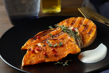 Concept of tasty eating with baked pumpkin on wooden background