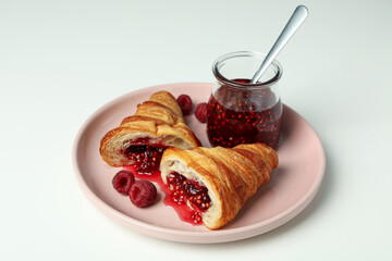 Concept of delicious food with croissant with raspberry jam on white background