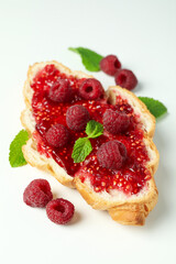 Croissant with raspberry jam on white background