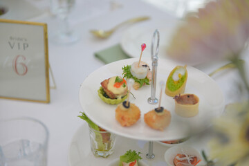 Catering and guest meals during the event. Quick mini snacks in a special beautiful dish. Canapes and light meals, tapas on the table in the restaurant,event, party or wedding reception.