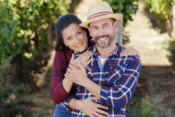 Fototapeta premium portrait of smiling couple hugging at vineyarf