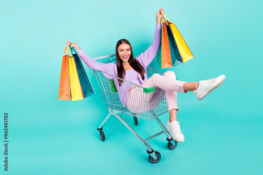 Canvas Prints Photo of dreamy funny young lady wear violet outfit smiling holding bargains ridding shopping tray isolated turquoise color background