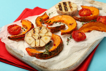 Concept of tasty food with baked pumpkin on blue background