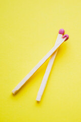two matches on a yellow paper table