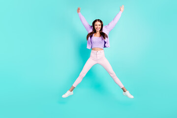 Fototapeta na wymiar Photo of excited sweet young lady wear violet outfit smiling jumping high like star isolated turquoise color background
