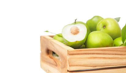 Green jojoba fruit and cut half in the wooden box isolated