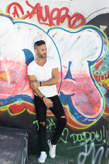 A young handsome bearded man posing in an urban background. High quality photo